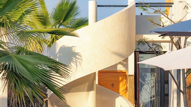 A modern building with a unique architectural design, featuring a curved structure and a glass facade. - Ola de Luna, Charming bungalow in El Pescadero with AC, Pool and yoga deck. (El Pescadero)