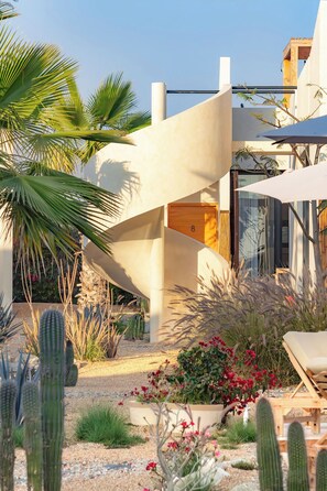 A modern building with a unique architectural design, featuring a curved structure and a glass facade. - Ola de Luna, Charming bungalow in El Pescadero with AC, Pool and yoga deck. (El Pescadero)