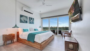 Ein modernes Schlafzimmer mit einem Holzbett, Blick ins Freie und einem Deckenventilator.