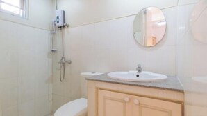 A bathroom with a toilet, a sink, a mirror, and a shower. - RedDoorz @ Moss Hotel Guevarra Dasmarinas (Dasmarinas)