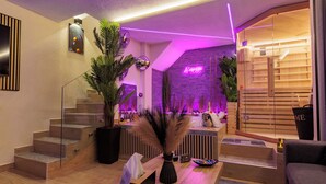 Een moderne lobby met een trap, een receptiebalie en een neonbord.