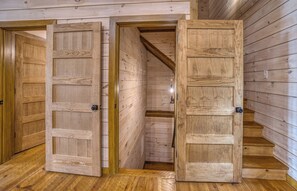A wooden interior with two open doors leading to a staircase. - New Luxury Cabin in Coosawattee River Resort _ Hot Tub + Views + Sleeps 12 (Ellijay)