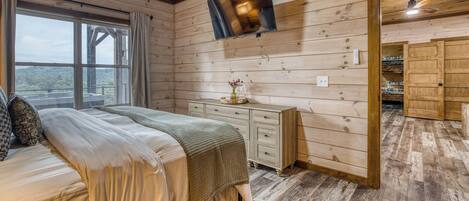 Un intérieur en bois comprenant un lit, une commode et un téléviseur fixé au mur.