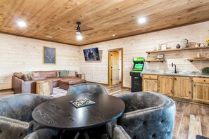 Ein gemütliches Zimmer mit Holzboden, einer Couch, einem Couchtisch und einer Spielkonsole.