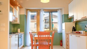 A compact kitchen with a dining table and chairs, a stove, and cabinets.