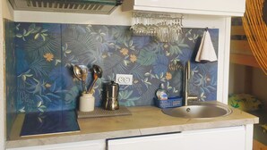A compact kitchen with a sink, a stove, and a countertop. - Studio on Frioul Island: at the foot of a beach and the Morgiret calanque. (Marseille)