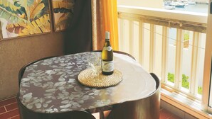 A balcony with a table, chairs, a bottle of wine, and a view of a marina. - Studio on Frioul Island: at the foot of a beach and the Morgiret calanque. (Marseille)