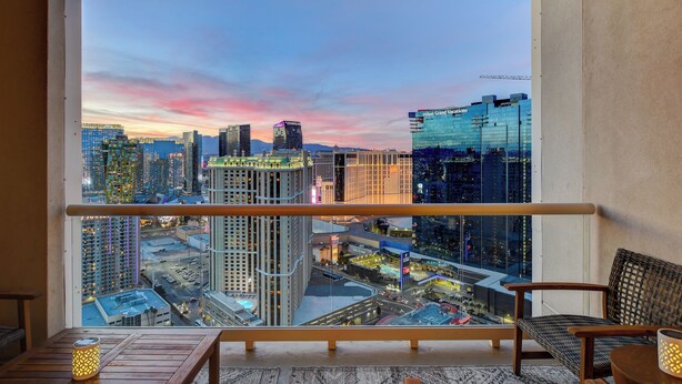Un balcón con vista a la ciudad al atardecer.