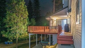Ein Haus mit überdachter Terrasse, Garage und gut beleuchtetem Eingang.
