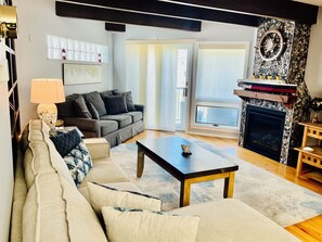 Relax in this stylish living room with a grey sofa, coffee table, and fireplace.
