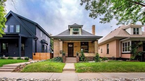 Une maison moderne à deux étages, dotée d’un porche à l’avant, d’une entrée en briques et d’une pelouse bien entretenue.