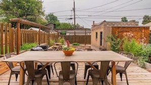 Une terrasse en bois avec une table rectangulaire et six chaises.