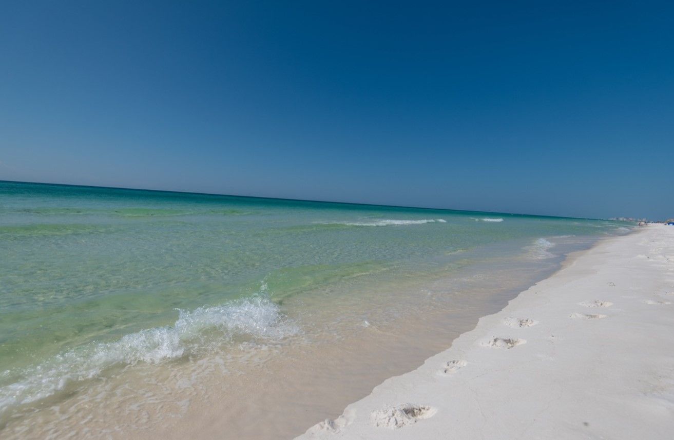 Una playa con aguas turquesas cristalinas y arena blanca.