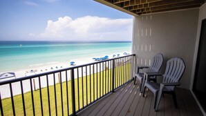 A balcony with a view of the beach and ocean. There are two Adirondack chairs and a small table. - Blue Mountain Condos #22 (Santa Rosa Beach)