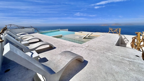 A rooftop infinity pool with lounge chairs and a view of the ocean. - Sunset hills Apartments  (Mazatlán)
