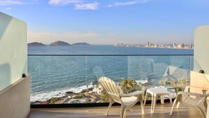 A balcony with a view of the ocean and a city skyline. - Sunset hills Apartments  (Mazatlán)