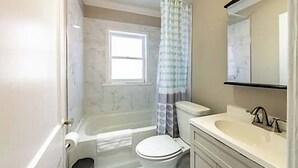 A bathroom with a bathtub, toilet, and sink. - The Park Overlook (Charlotte)