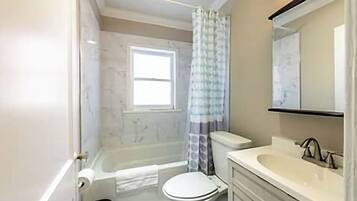 Une salle de bain avec une baignoire, des toilettes et un lavabo.