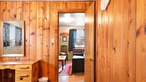 A wooden-paneled room with a desk, chair, and a mirror. - "A" Antelope Cabin - South Fork (South Fork)
