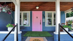 A house with a pink door, number 39, and a green mat with "Hello Sunshine" on it.