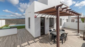 A modern outdoor patio with a pergola, a pool, and a dining area. - Vacation Villa 'Luxury  Lanzarote' with Sea View, Private Pool and Wi-Fi (Playa Blanca)