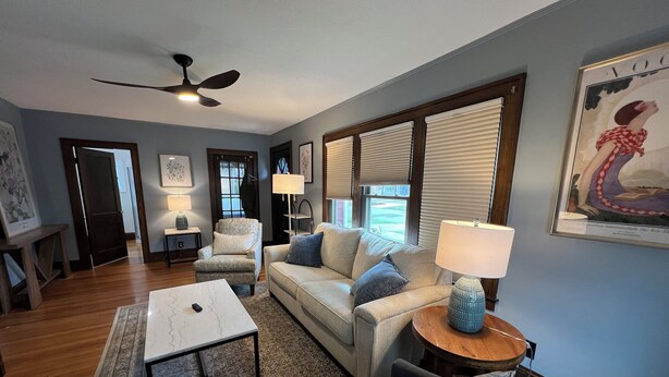 A living room with a sofa, armchairs, a coffee table, and a ceiling fan. - Warm, charming 3BR house w fenced yard in quiet neighborhood close to everything (Springfield)
