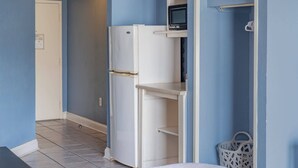 A compact kitchenette with a white refrigerator, a microwave, and a small shelf. - Ocean View Condo Sleeps 4! (Myrtle Beach)