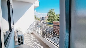 A balcony with a metal railing, a view of the sky, and a building in the background. - Boya Apartments (Abuja)