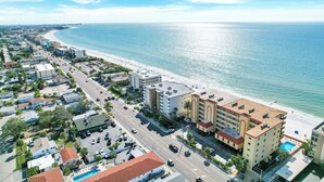 Un hotel frente al mar con varias plantas, piscina y vistas a la playa.