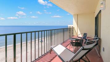 A balcony with a view of the beach and ocean.