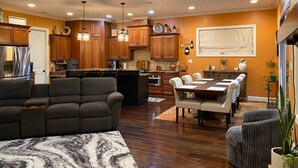 A spacious living room with a large sofa and a dining area with a table and chairs. - Spacious 5-bedroom, 3-bathroom Masters ready house.  14 miles from Nationals GC. (Evans)