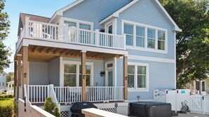 Ein zweistöckiges Haus mit Balkon, Garage und überdachter Terrasse.
