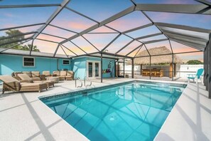 Zona de piscina con vistas despejadas al cielo, una estructura de techo de paja y un área de descanso con sillones.
