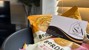 Un paquet de biscuits Borde et une carte de visite de Simply Accommodation.