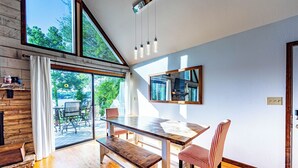 A dining area with a wooden table and bench, large windows, and a view of the outdoors. - Sparta Escape a perfect getaway (Sparta)