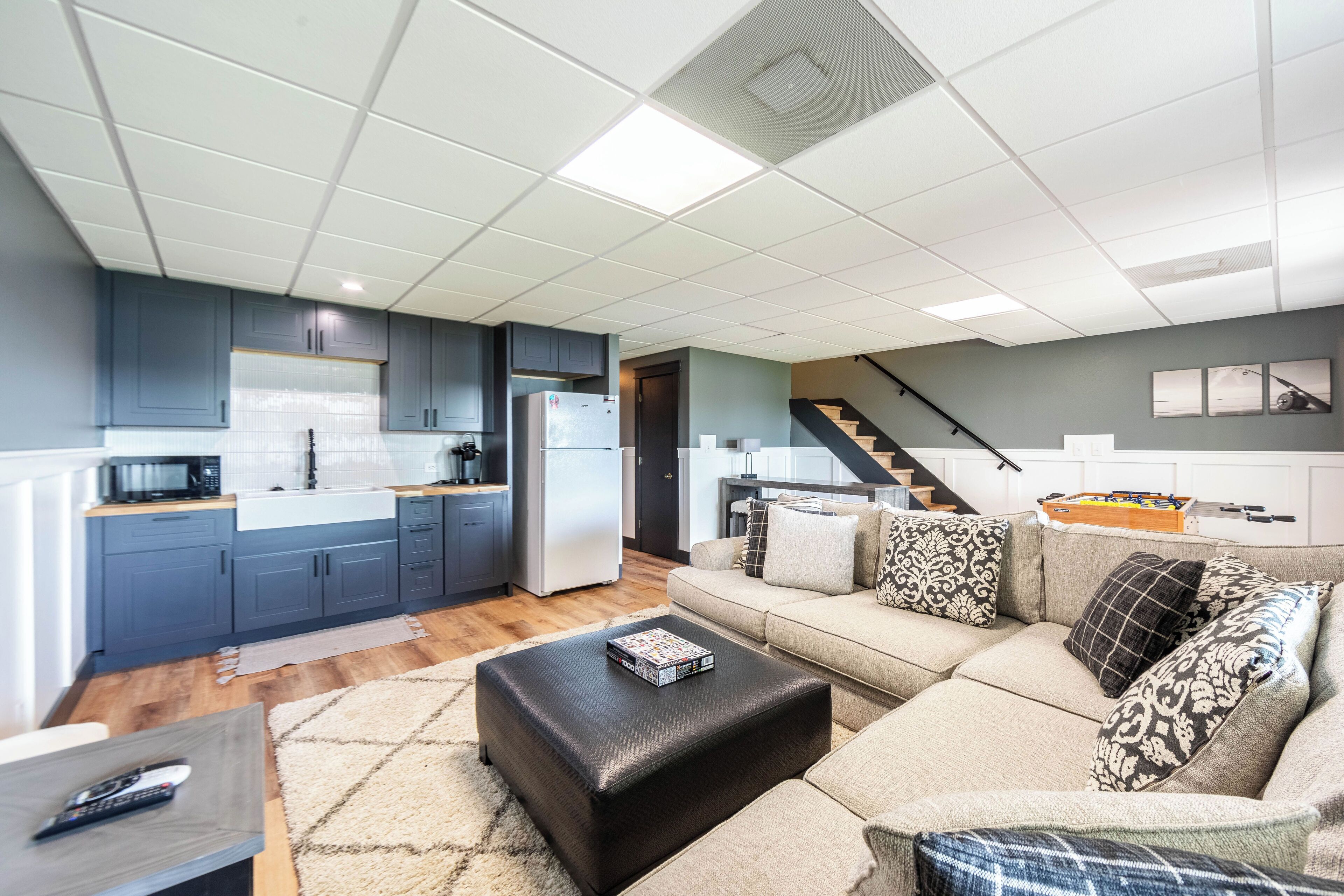 A modern apartment with a kitchen, living room, and staircase.