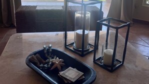 A room with a large window overlooking a pool and palm trees. There is a tray with starfish and a candle in a lantern. - Paradise Awaits: Beachfront, 2 Master Suites in San José del Cabo (San José del Cabo)