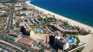 An aerial view of a coastal resort with multiple buildings, a beach, and a swimming pool complex. - Paradise Awaits: Beachfront, 2 Master Suites in San José del Cabo (San José del Cabo)