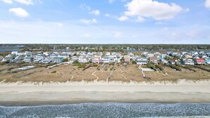 Zona residencial costera con casas, una playa y cielo despejado.