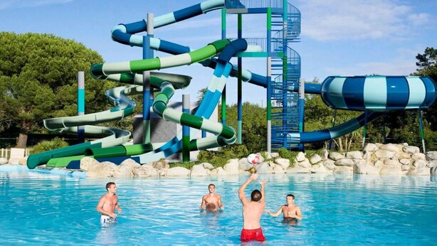 Una piscina con múltiples toboganes y una fuente de agua en espiral.