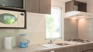 Una cocina moderna equipada con microondas, tetera y estufa.