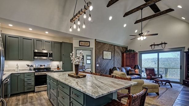 A spacious kitchen with a large island, built-in appliances, and a dining area with a view. - The Owlery, Walk to Town (Highlands)