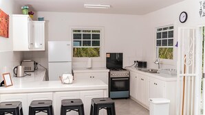 A modern kitchen with white cabinets, a built-in oven, a stove, and a large window.