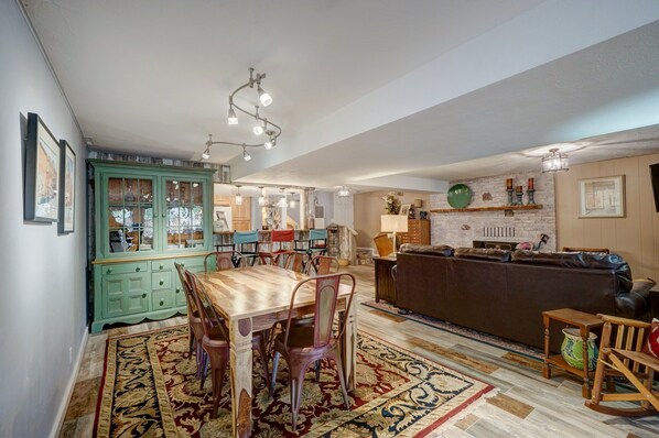 A dining area with a wooden table and chairs, a green cabinet, and a patterned rug. - River Place Retreat, Unit 4- Cozy Condo on the Arkansas River (Howard)