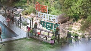 A pool area with a sign, railings, and potted plants. - SUKOON DK (Jakholi)