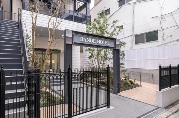 The entrance to Bande Hotel with a gated driveway and a staircase leading to the entrance. - Bande Hotel Osaka (Osaka)