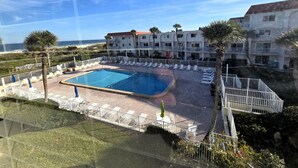 A hotel with a swimming pool, lounge chairs, and a view of the ocean. - Oceanview Townhouse with Pool & Balcony Access (Saint Augustine)
