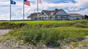A large, two-story building with a gabled roof and a porch. - The Pearl by Sandpiper | Near Beach (Seabrook Island)