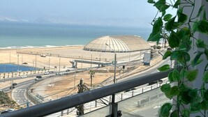 Un balcone con vista su una strada costiera e uno stadio.