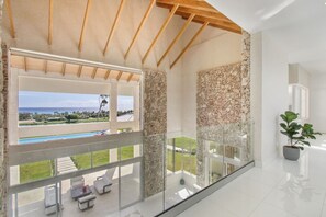 Un balcón amplio con vistas despejadas a una piscina y un paisaje verde exuberante.